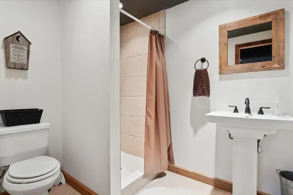 a bathroom with a toilet a sink and mirror