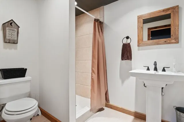 a bathroom with a toilet a sink and mirror