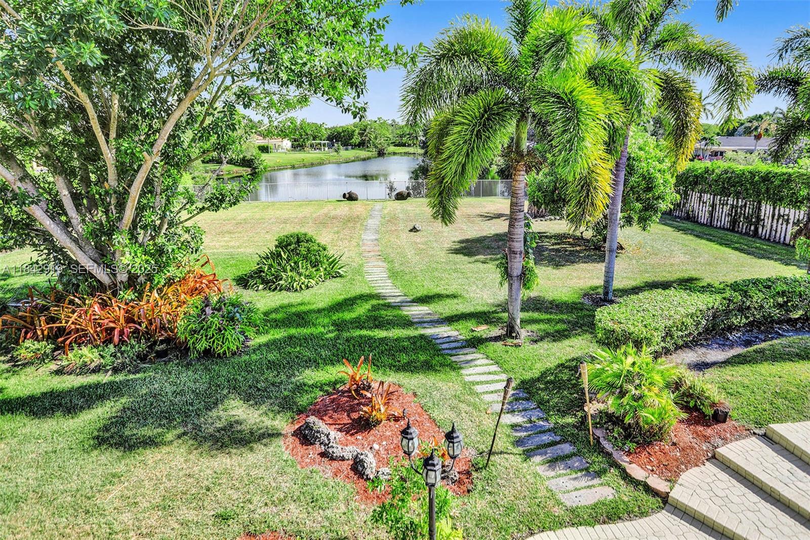 721 Ranch Road Weston, FL 33326 - Photo 15 of 38 a view of backyard with a garden and trees