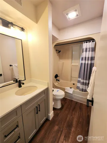 a bathroom with a double vanity sink toilet mirror and tub