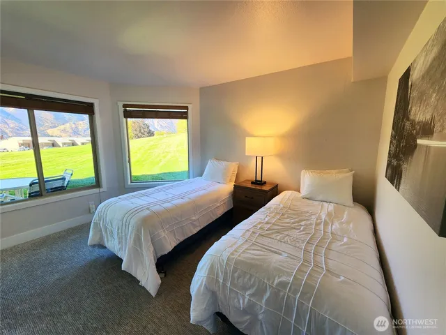 a bedroom with two beds and a large window