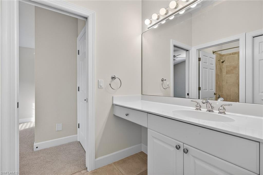 8968 Morgan Court Naples, FL 34113 - Photo 16 of 32 a bathroom with a double vanity sink and a mirror