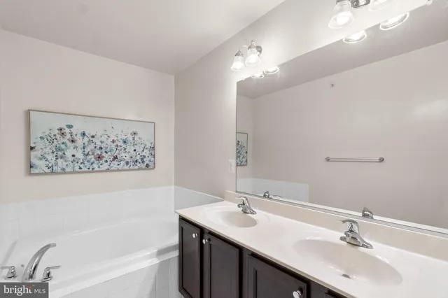 a bathroom with a tub double sink and mirror