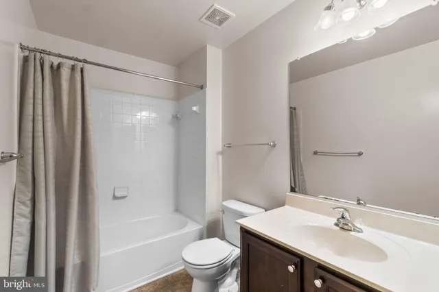 a bathroom with a sink a toilet a mirror and shower