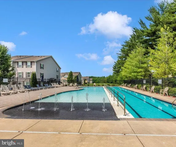 a view of a swimming pool with a patio and a yard