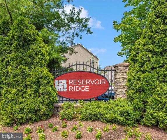 a sign of golf club on a wall under a tree