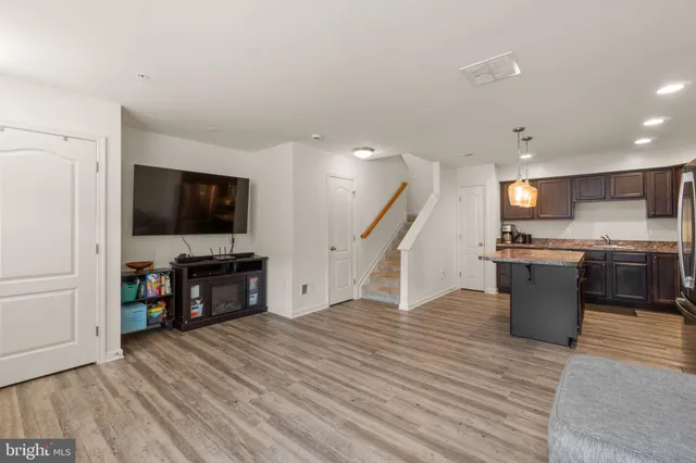 a view of kitchen with microwave refrigerator and wooden floor