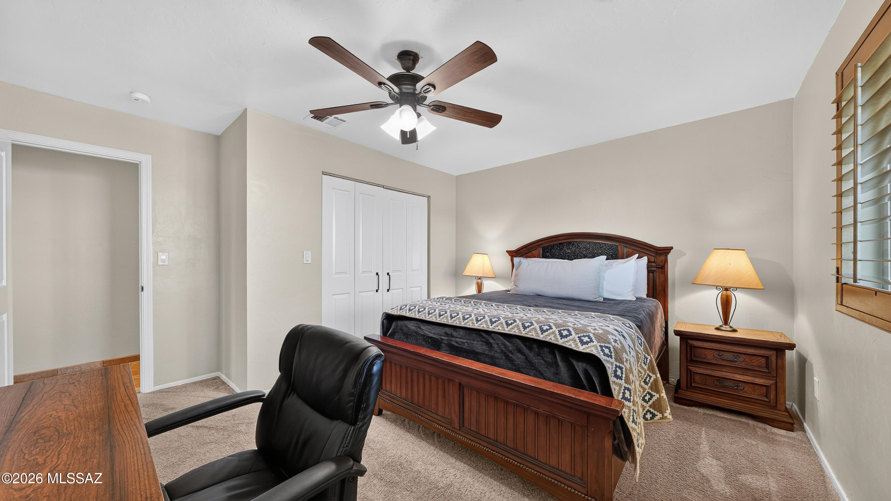 194 Taylor Road Willcox, AZ 85643 - Photo 29 of 54 Bedroom 2 - well-sized, large closet, custom wood window shutters, ceiling fan, and enough space for both sleeping and workspace needs.