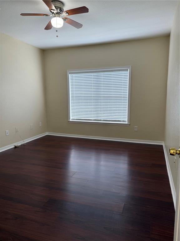 3725 Conroy Road, Unit 2127 Orlando, FL 32839 - Photo 16 of 30 an empty room with wooden floor fan and windows