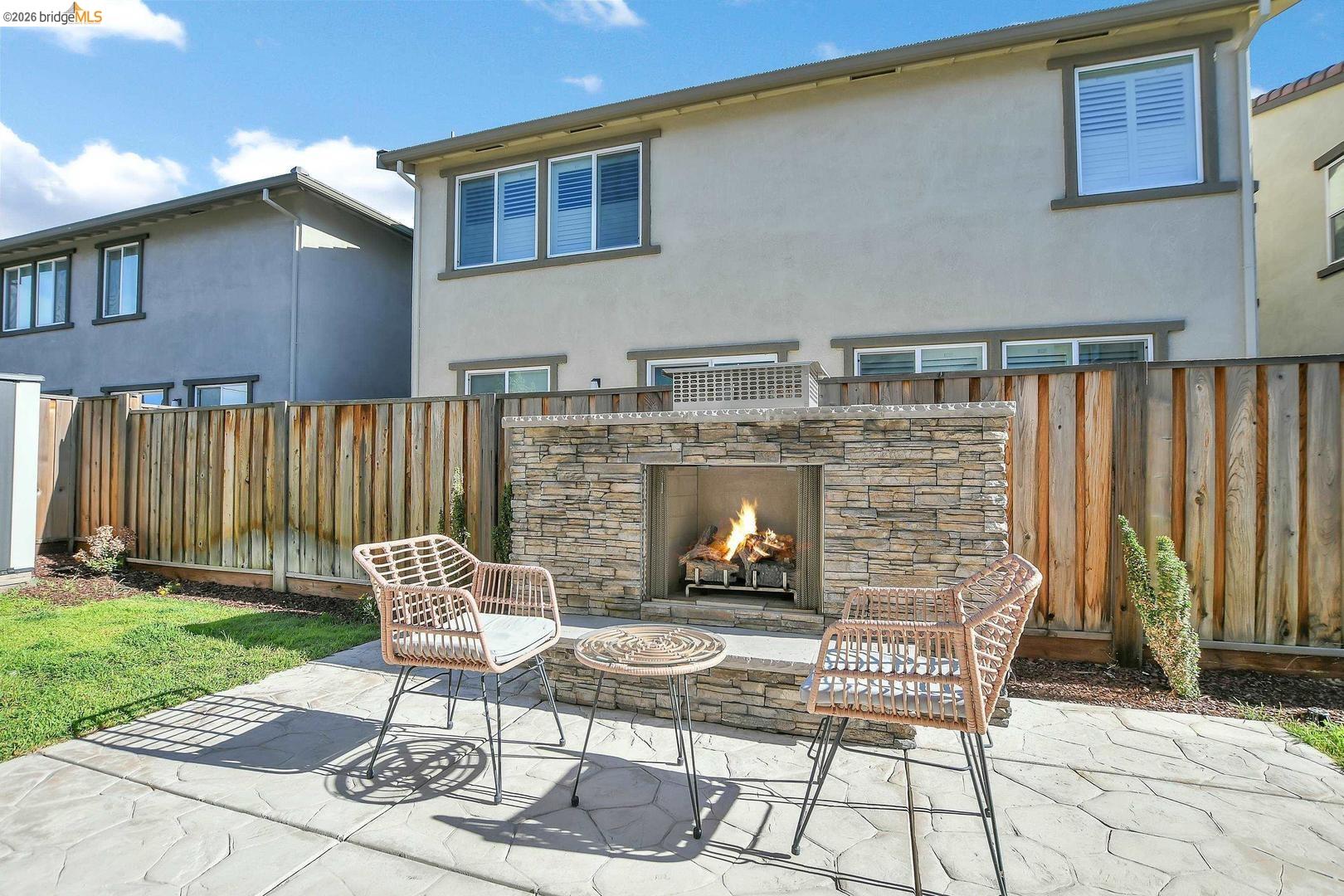 829 Hardcastle Ranch Road Oakley, CA 94561 - Photo 38 of 42 Backyard featuring a stone-clad outdoor fireplace, concrete patio, and fenced perimeter