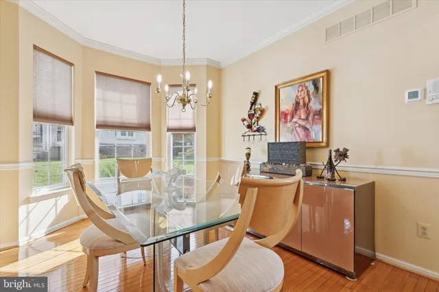a view of a dining room with furniture a chandelier and wooden floor