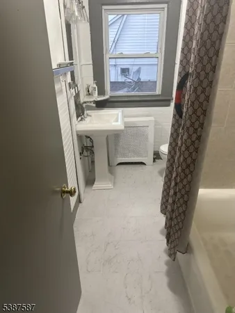 a bathroom with a bathtub sink and mirror