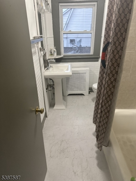 a bathroom with a bathtub sink and mirror