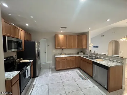 a kitchen with stainless steel appliances granite countertop a sink stove and refrigerator