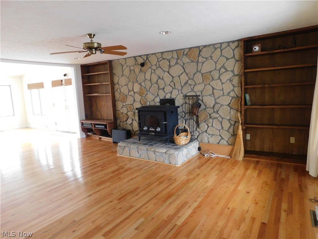 381 Lance Road Davisville, WV 26142 - Photo 3 of 34 Space I will refer to as Great Room. Notice the beautiful wood flooring, wood stove, stone fireplace and book cases. Security system stays as well as surround sound unit that is only in the lower level living areas.