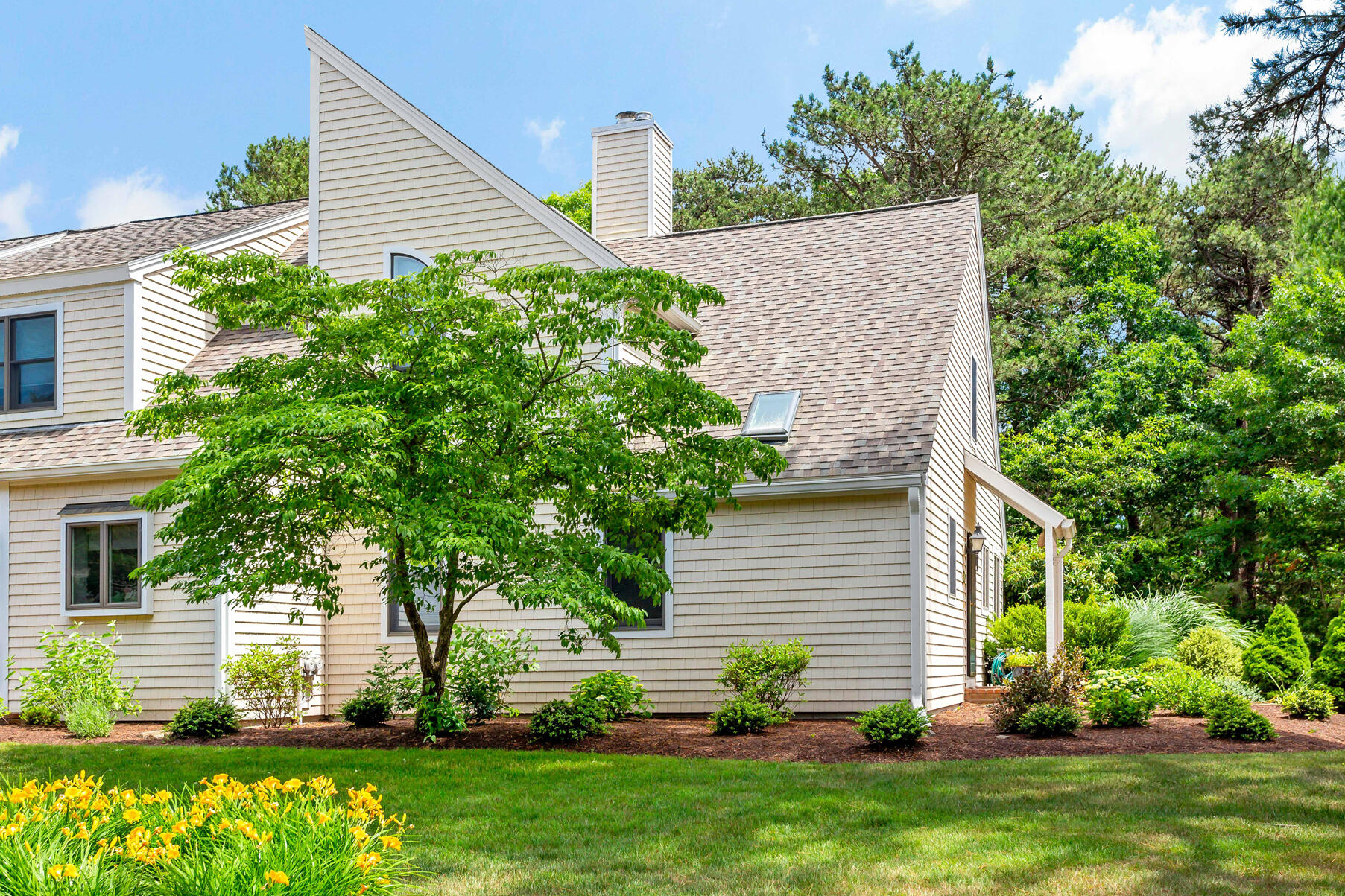 35 Shellback Way, Unit E Mashpee, MA 02649 - Photo 1 of 29 a front view of a house with a yard and potted plants