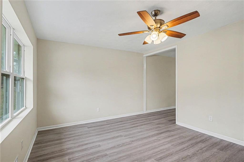 8355 Dunellen Lane Jonesboro, GA 30238 - Photo 12 of 27 a view of an empty room with wooden floor and a ceiling fan