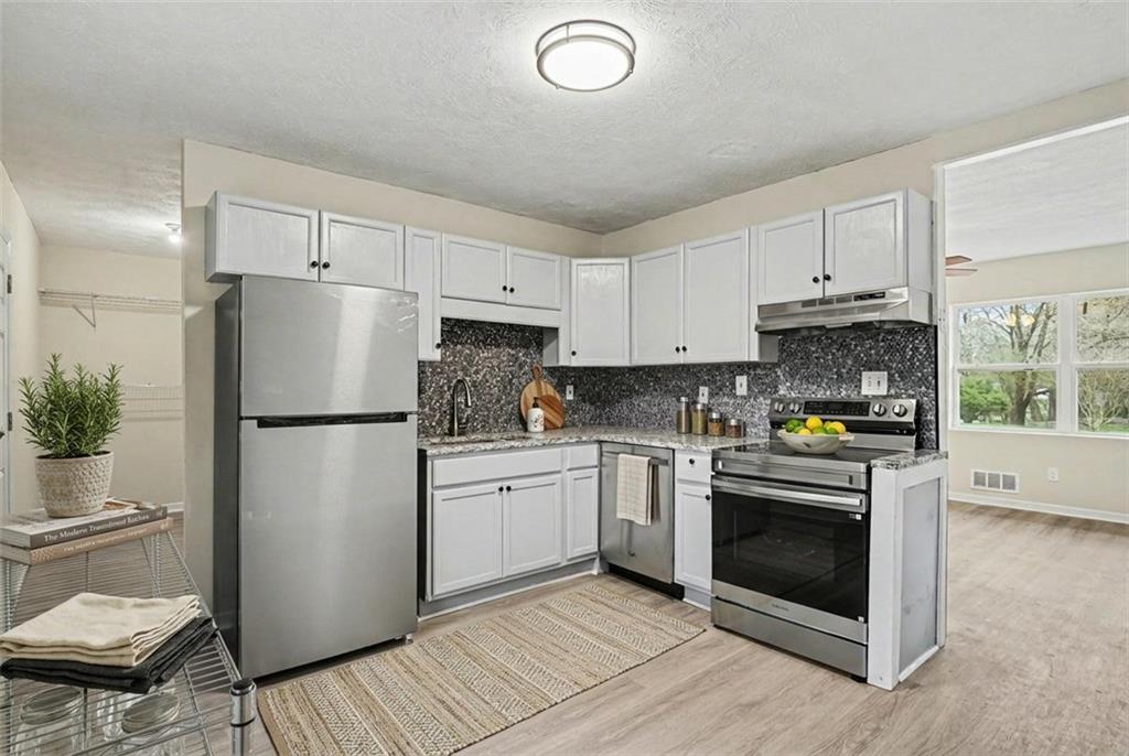 8355 Dunellen Lane Jonesboro, GA 30238 - Photo 14 of 27 a kitchen with a refrigerator sink and white cabinets