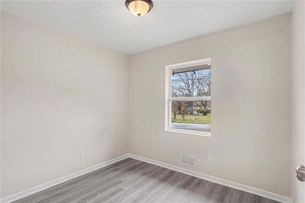 8355 Dunellen Lane Jonesboro, GA 30238 - Photo 18 of 27 an empty room with wooden floor and window