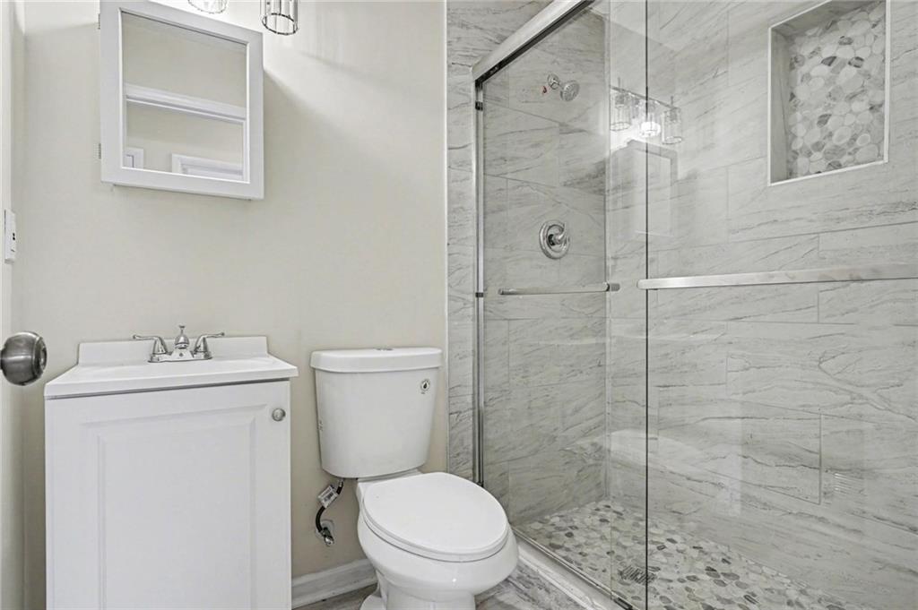 8355 Dunellen Lane Jonesboro, GA 30238 - Photo 3 of 27 a bathroom with a toilet a sink and shower