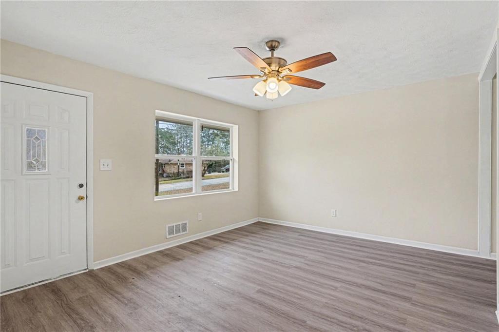 8355 Dunellen Lane Jonesboro, GA 30238 - Photo 10 of 27 a view of an empty room with wooden floor and a window