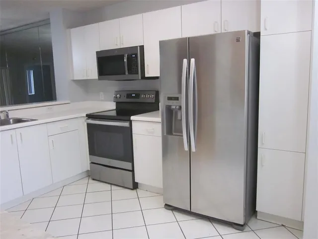 a kitchen with stainless steel appliances a refrigerator and a stove top oven