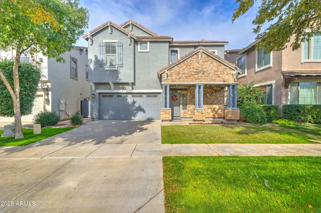 a front view of a house with a yard and potted plants