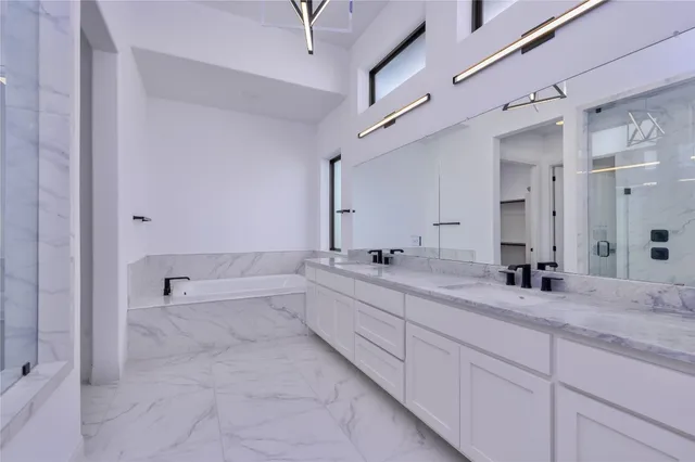 a bathroom with a granite countertop sink mirror and bathtub