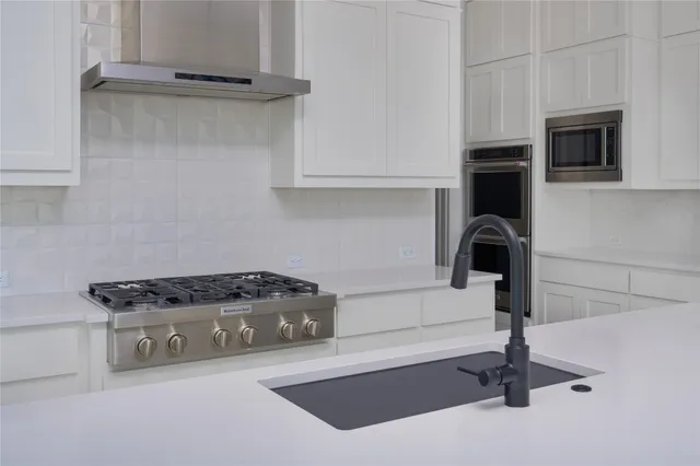 a kitchen with granite countertop a stove and a sink