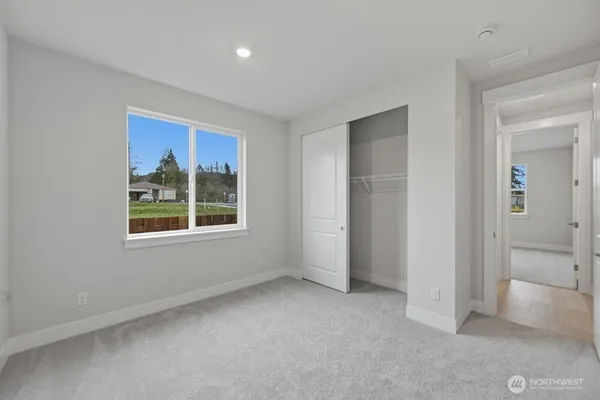 an empty room with windows and closet