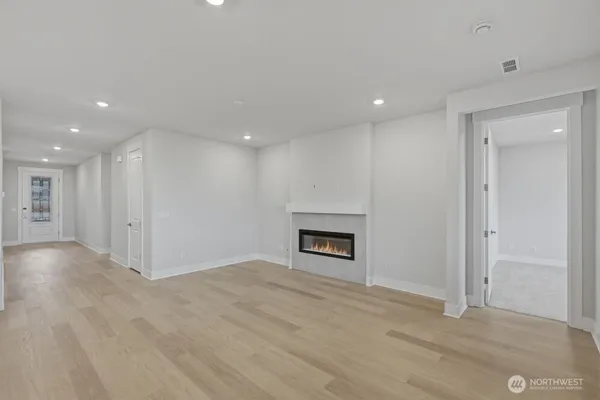 an empty room with kitchen and fireplace