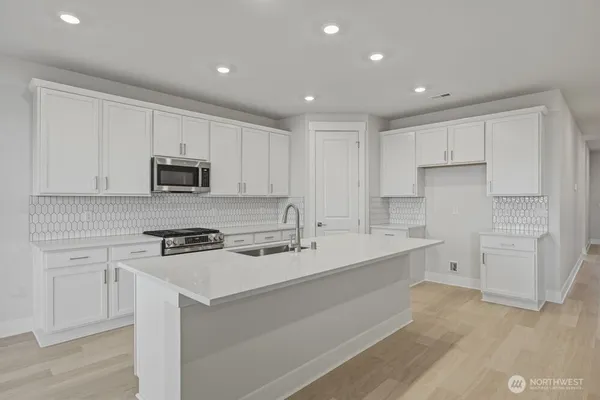 a kitchen with white cabinets stainless steel appliances and sink