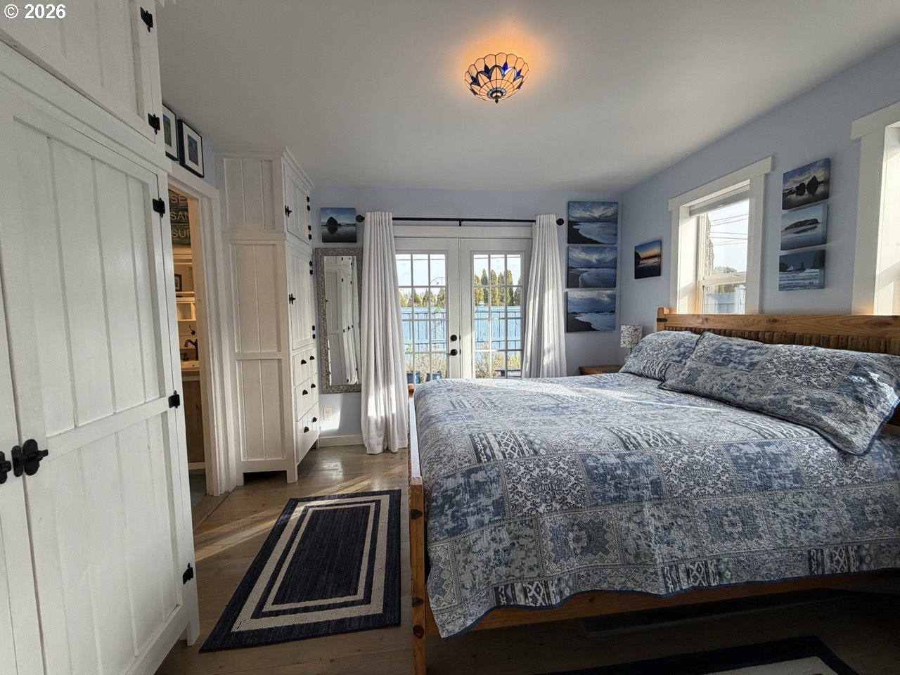 886 1st Street Southeast Bandon, OR 97411 - Photo 16 of 40 a bedroom with a bed and a large window with balcony view