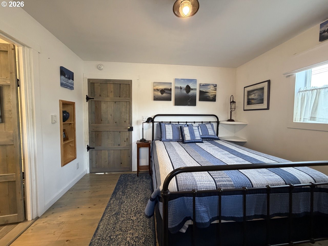 886 1st Street Southeast Bandon, OR 97411 - Photo 23 of 40 a bedroom with a bed and wooden floor