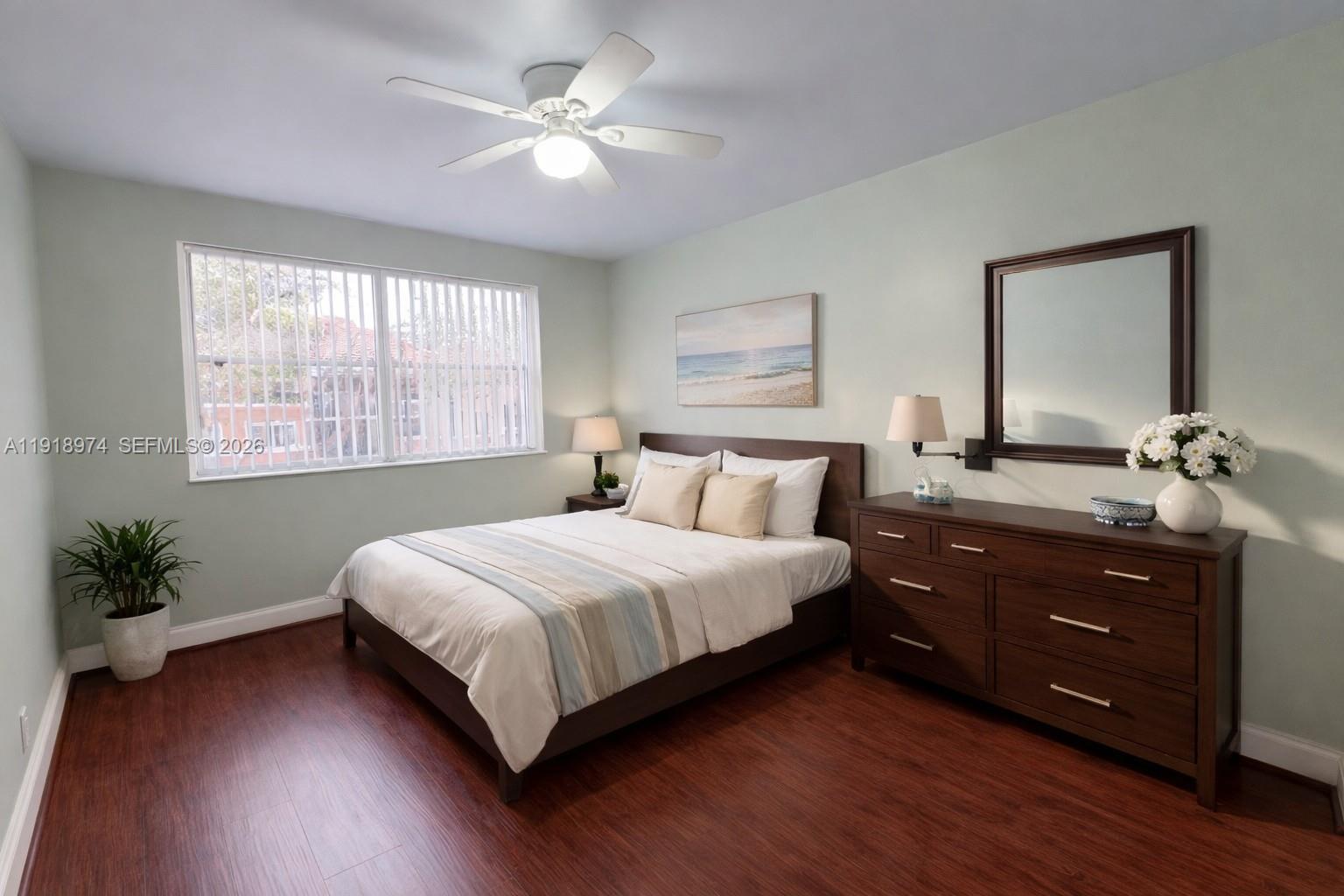 8801 Wiles Road, Unit 307 Coral Springs, FL 33067 - Photo 12 of 18 a bedroom with a bed chandelier and a window