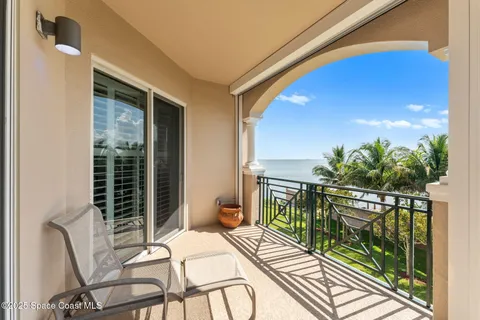 a view of balcony with two chairs and potted plants