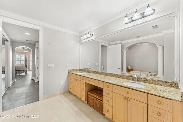 a bathroom with a granite countertop double vanity sink and a mirror