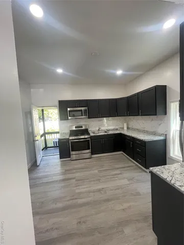 a kitchen with stainless steel appliances kitchen island granite countertop a stove and a sink