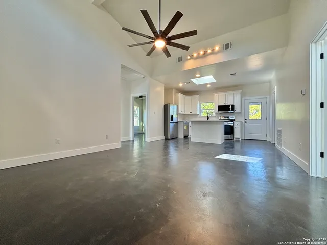 a view of an empty room with a kitchen