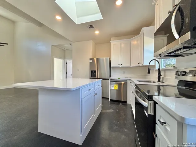 a kitchen with cabinets a sink and appliances