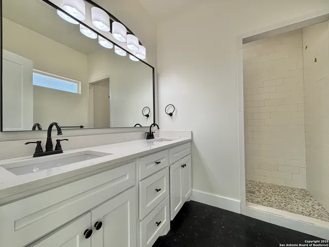a bathroom with a double vanity sink and a mirror