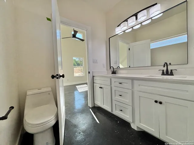 a spacious bathroom with a granite countertop sink toilet and shower
