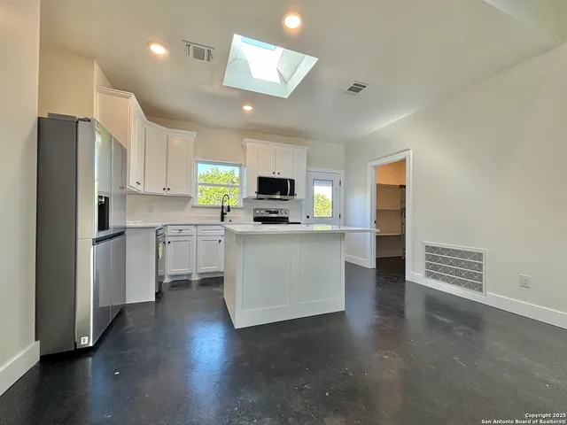 a kitchen with stainless steel appliances a refrigerator and a stove top oven