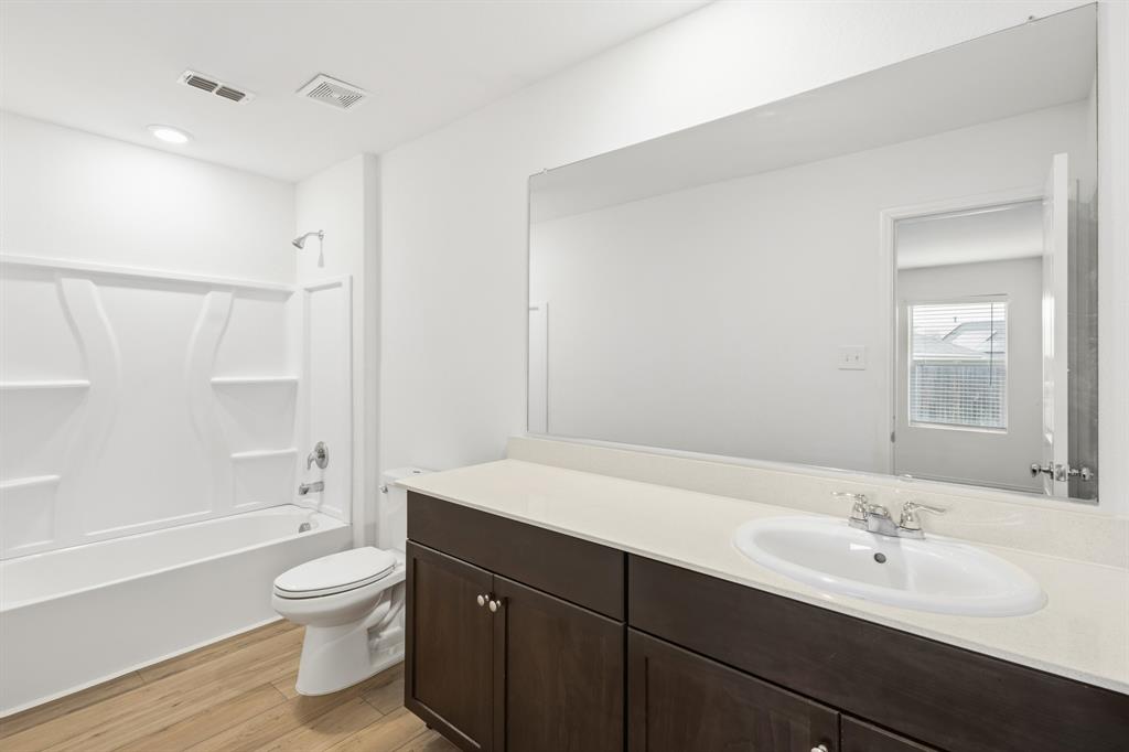 2604 Spring Time Drive Ennis, TX 75119 - Photo 18 of 21 a bathroom with a sink a toilet and a large mirror