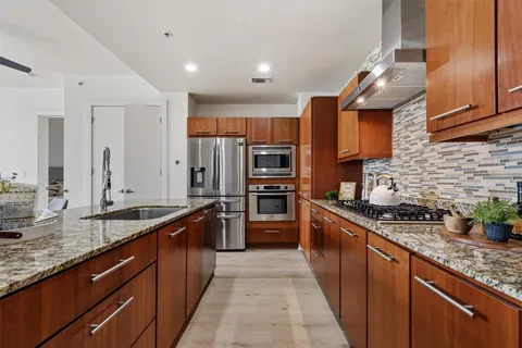 a kitchen with stainless steel appliances granite countertop a sink stove and refrigerator