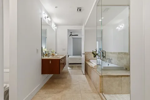 a large bathroom with a double vanity sink a large mirror and a shower