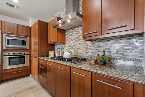 a kitchen with stainless steel appliances granite countertop a sink stove and microwave