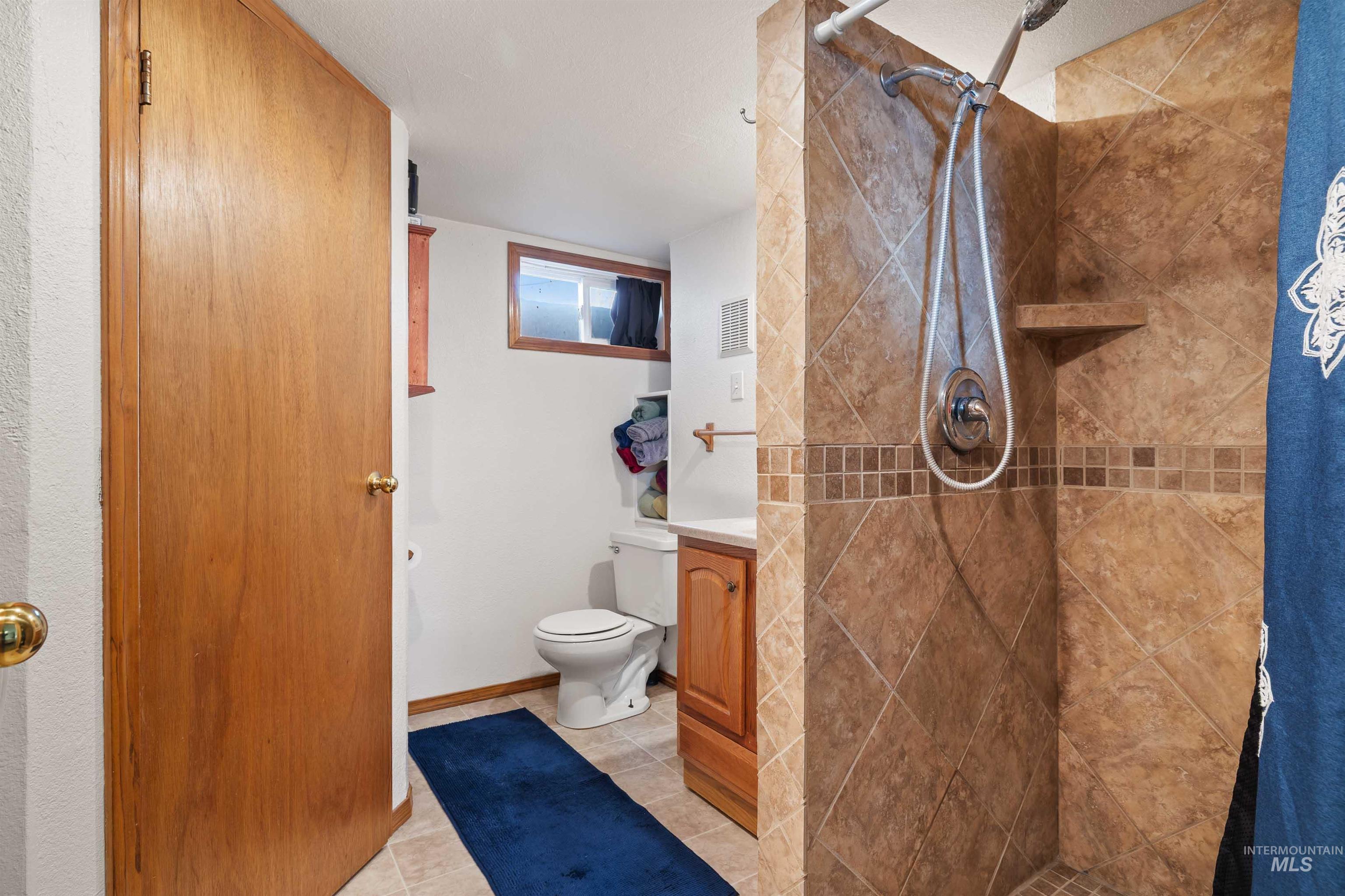 753 Ash Street Twin Falls, ID 83301 - Photo 12 of 25 Full bathroom featuring a stall shower, light tile patterned floors, and vanity