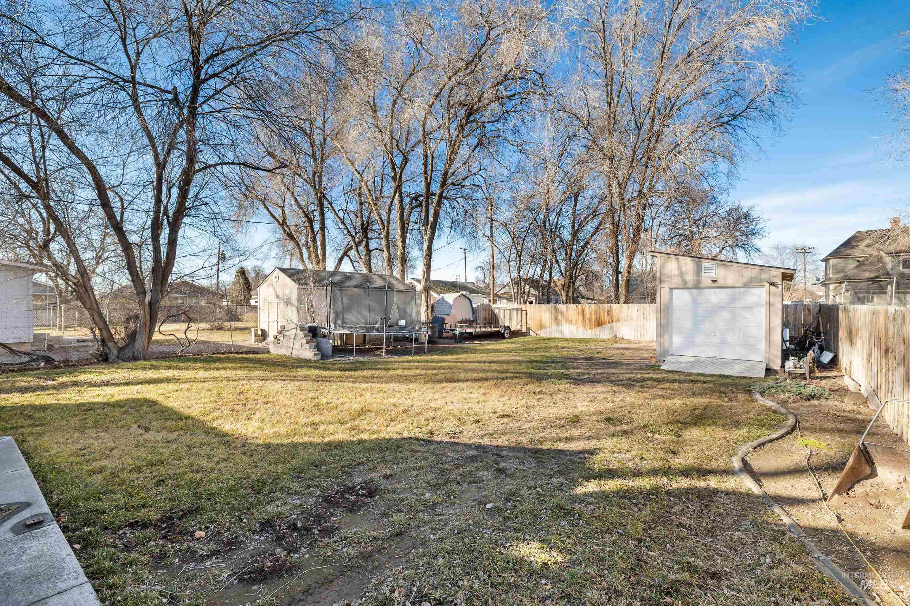 753 Ash Street Twin Falls, ID 83301 - Photo 22 of 25 Fenced backyard with a trampoline and a storage shed