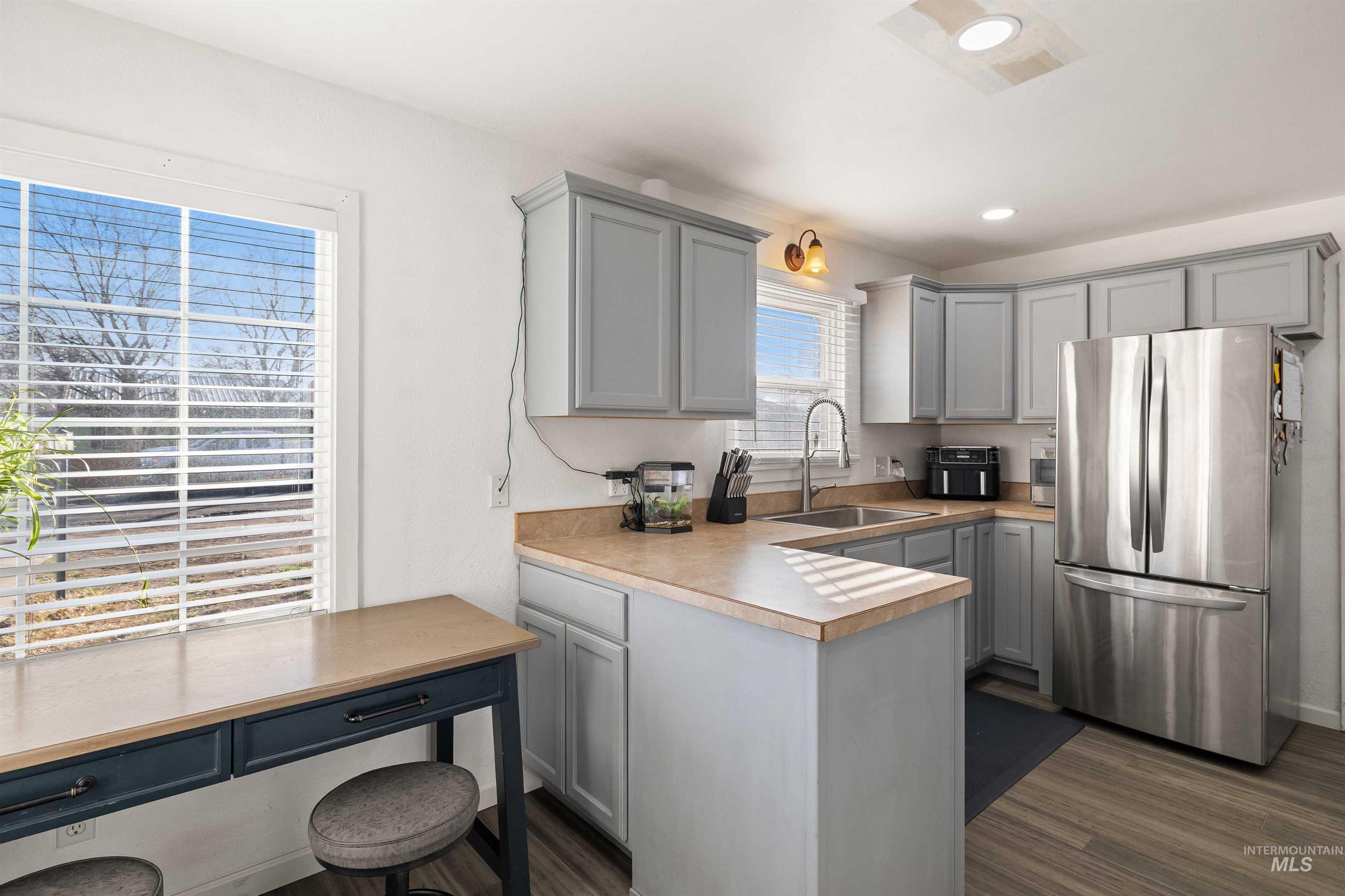 753 Ash Street Twin Falls, ID 83301 - Photo 6 of 25 Kitchen featuring freestanding refrigerator, gray cabinets, light countertops, and dark wood-style floors